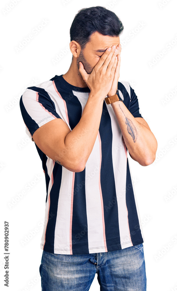 Young handsome hispanic man wearing striped tshirt with sad expression covering face with hands while crying. depression concept. Young handsome hispanic man wearing striped tshirt with sad expression covering face with hands while crying. depression concept.