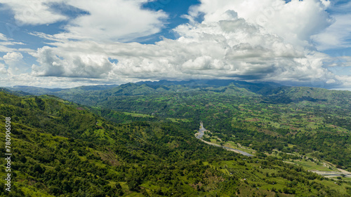 Top view of river in a mountain valley among agricultural land and rice fields. Negros, Philippines