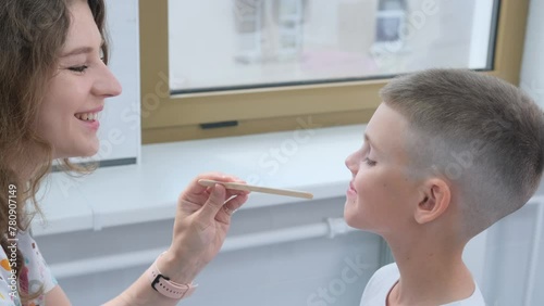 Pediatric Speech Therapist Conducting Articulation Exercise With Young Boy in Clinic