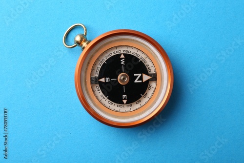 One compass on light blue background, top view