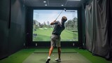 Golfer playing golf in indoor simulator Mixed media