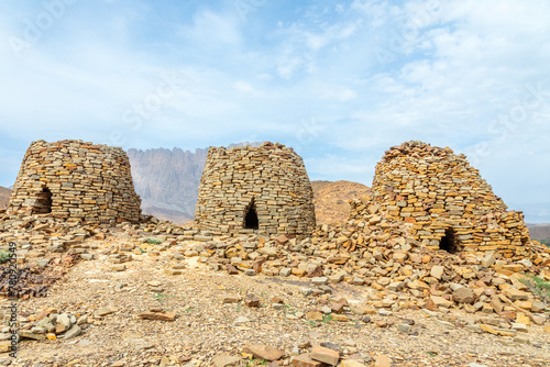 Ancient stone beehive tombs with Jebel Misht mountain in the background, archaeological site near al-Ayn, sultanate Oman