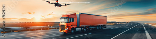 A red cargo truck speeds along a smooth highway at sunset, under the watchful eye of a flying drone