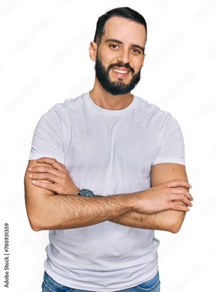 Young man with beard wearing casual white t shirt happy face smiling with crossed arms looking at the camera. positive person. Young man with beard wearing casual white t shirt happy face smiling with crossed arms looking at the camera. positive person.