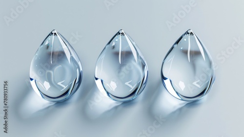 Three clear glass tear shaped objects on a white surface. Suitable for various concepts and designs photo