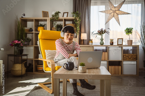 Woman sit at home use laptop computer to watch movie have video call