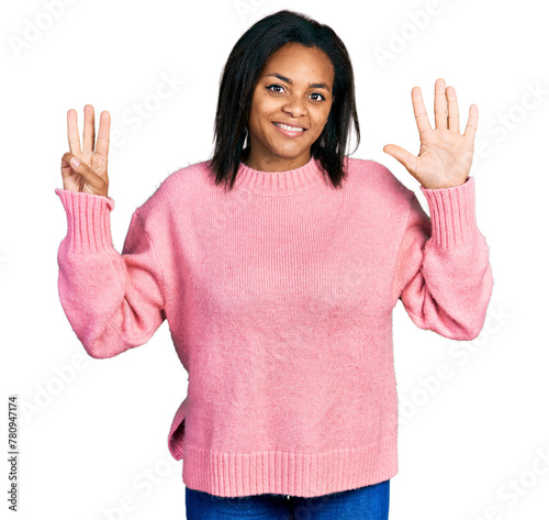 Beautiful hispanic woman wearing casual winter sweater showing and pointing up with fingers number eight while smiling confident and happy.