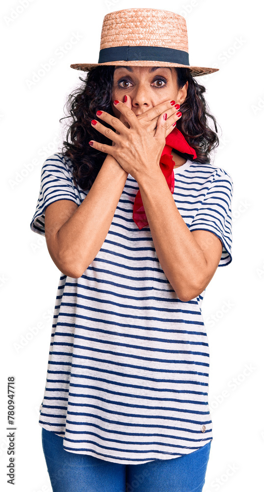 Middle age beautiful woman wearing casual striped t shirt and summer hat shocked covering mouth with hands for mistake. secret concept. Middle age beautiful woman wearing casual striped t shirt and summer hat shocked covering mouth with hands for mistake. secret concept.