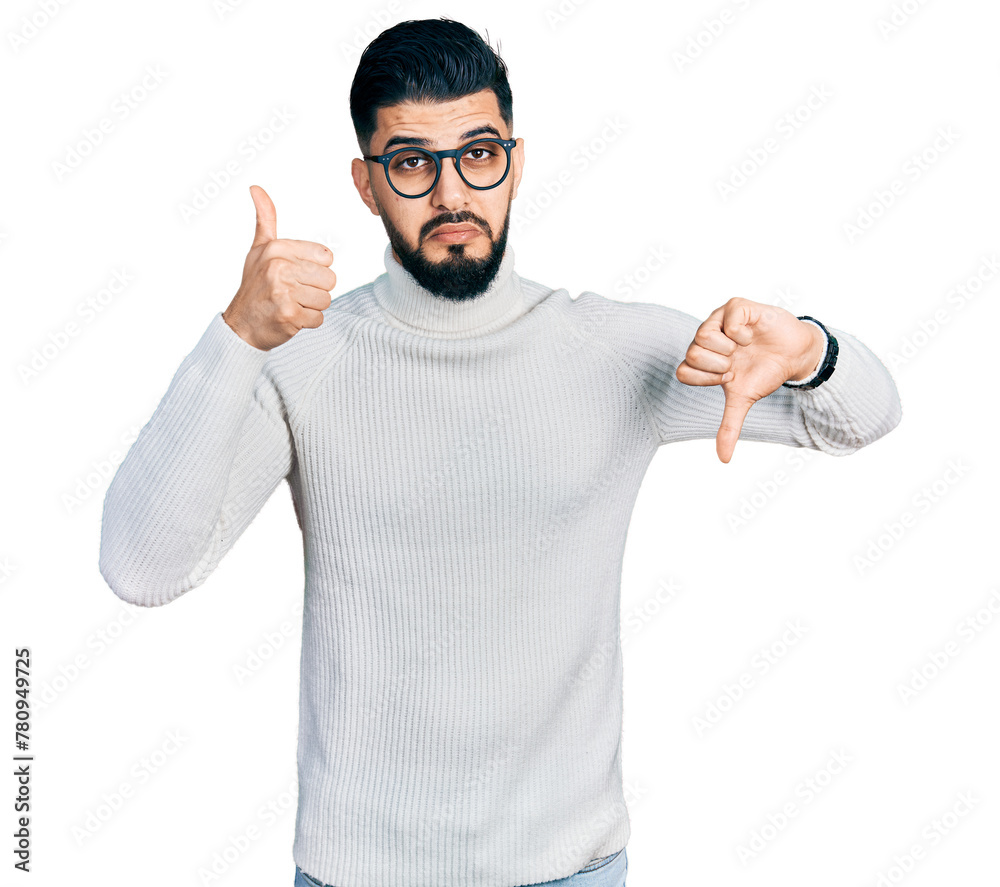 Young arab man with beard wearing elegant turtleneck sweater and glasses doing thumbs up and down, disagreement and agreement expression. crazy conflict Young arab man with beard wearing elegant turtleneck sweater and glasses doing thumbs up and down, disagreement and agreement expression. crazy conflict