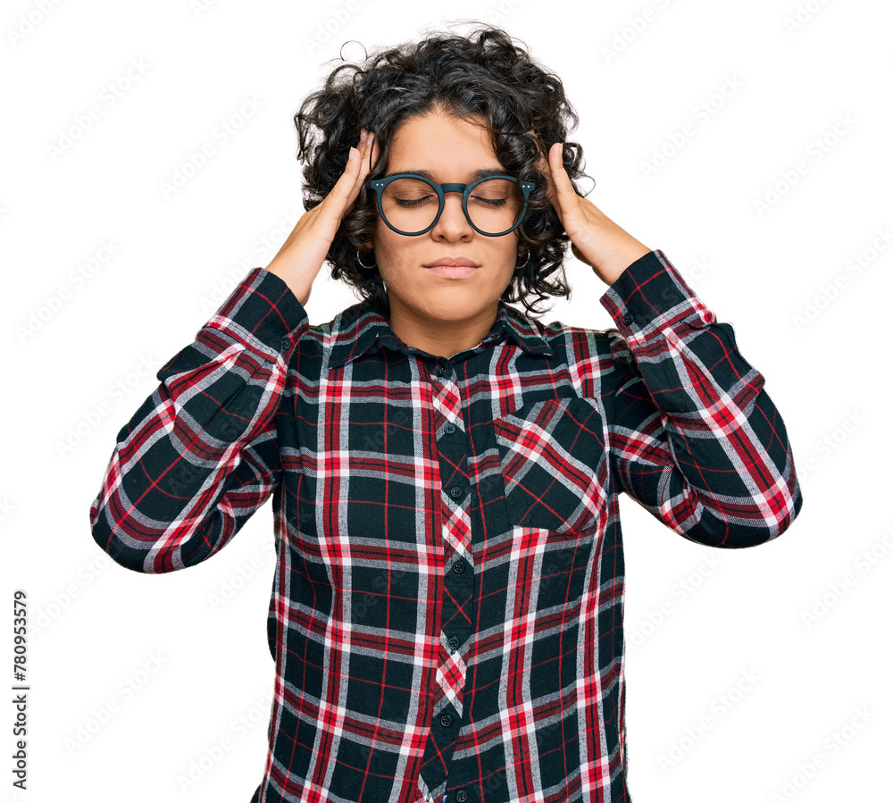 Young hispanic woman with curly hair wearing casual clothes and glasses suffering from headache desperate and stressed because pain and migraine. hands on head. Young hispanic woman with curly hair wearing casual clothes and glasses suffering from headache desperate and stressed because pain and migraine. hands on head.