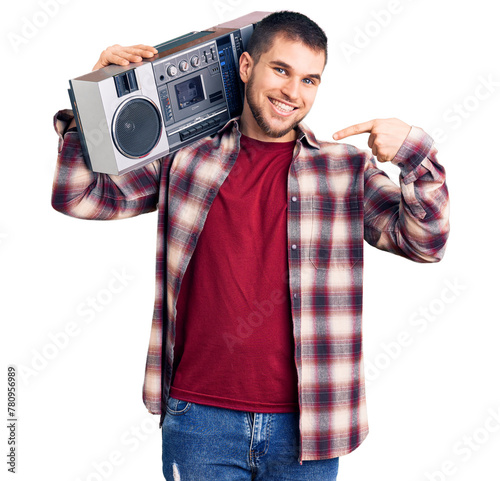 Young handsome man listening to music holding boombox pointing finger to one self smiling happy and proud