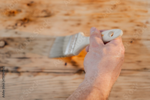  hand paints wooden boards with oil.Oil and varnish for wood. Impregnation of a wood with protective oil. Impregnation of wood with oil.Protecting the wooden surface from damage.