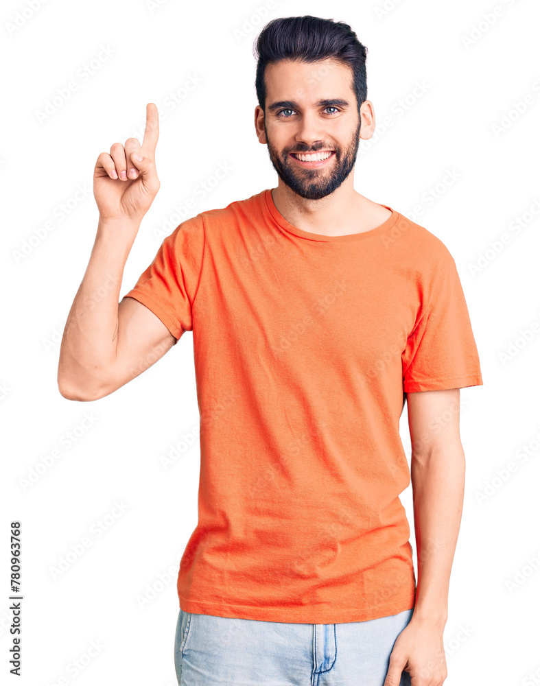 Young handsome man with beard wearing casual t-shirt showing and pointing up with finger number one while smiling confident and happy. Young handsome man with beard wearing casual t-shirt showing and pointing up with finger number one while smiling confident and happy.