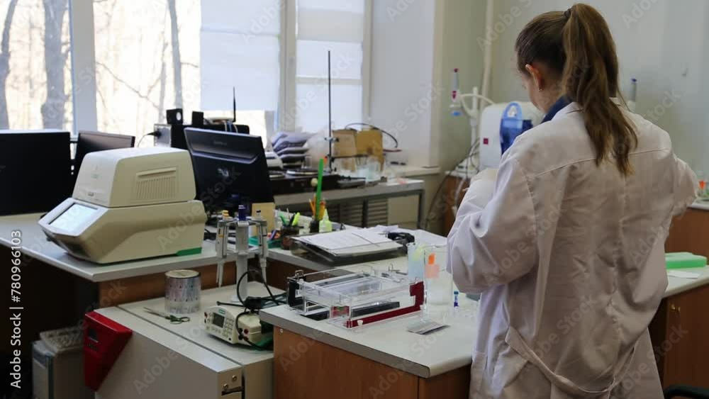 Scientist puts samples with DNA fragments into agarose gel for separation of DNA fragments for electrophoresis