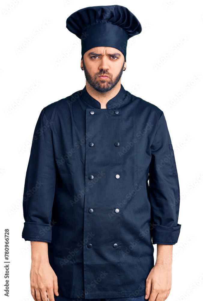 Young hispanic man wearing cooker uniform skeptic and nervous, frowning upset because of problem. negative person. Young hispanic man wearing cooker uniform skeptic and nervous, frowning upset because of problem. negative person.