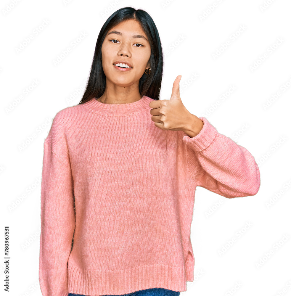Beautiful young asian woman wearing casual winter sweater doing happy thumbs up gesture with hand. approving expression looking at the camera showing success. Beautiful young asian woman wearing casual winter sweater doing happy thumbs up gesture with hand. approving expression looking at the camera showing success.
