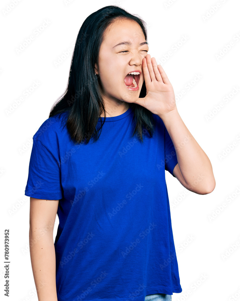 Young chinese woman wearing casual blue t shirt shouting and screaming loud to side with hand on mouth. communication concept. Young chinese woman wearing casual blue t shirt shouting and screaming loud to side with hand on mouth. communication concept.