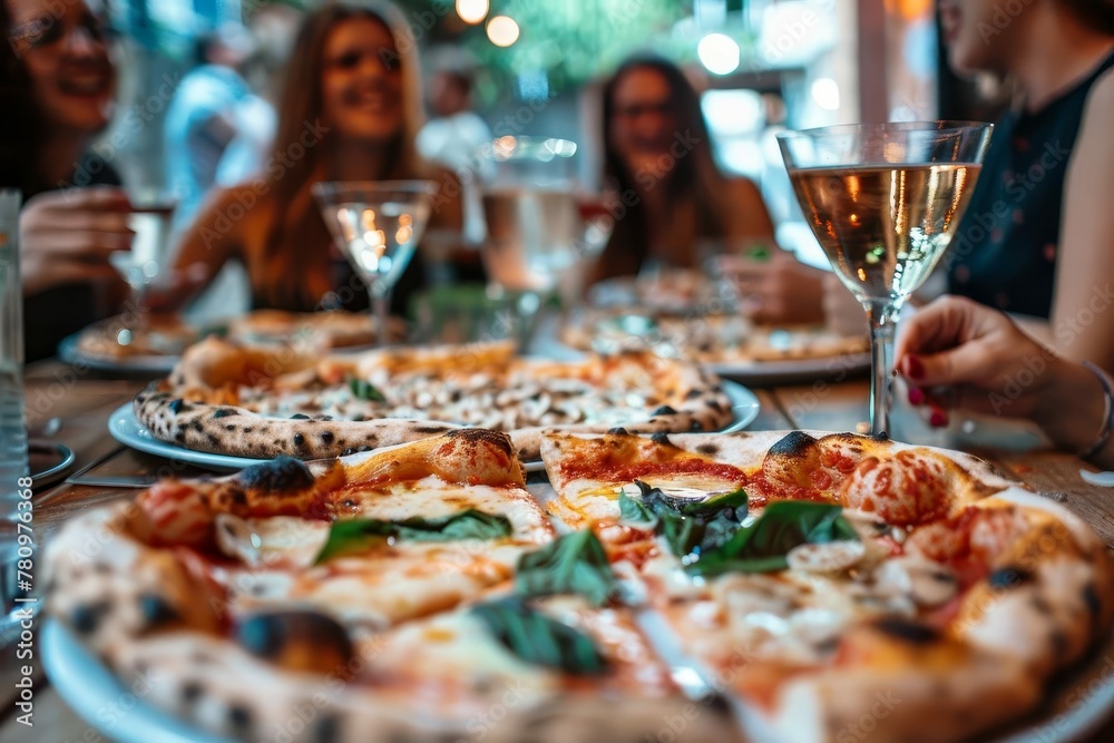 Friends enjoying pizza together at restaurant, laughing and socializing over dinner in the city, lifestyle photography