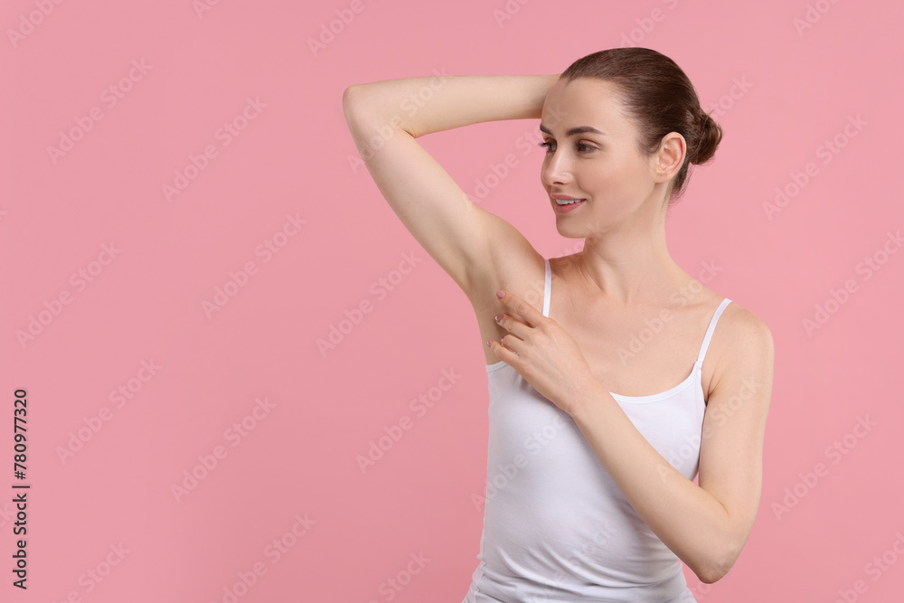 Beautiful woman showing armpit with smooth clean skin on pink background, space for text Beautiful woman showing armpit with smooth clean skin on pink background, space for text