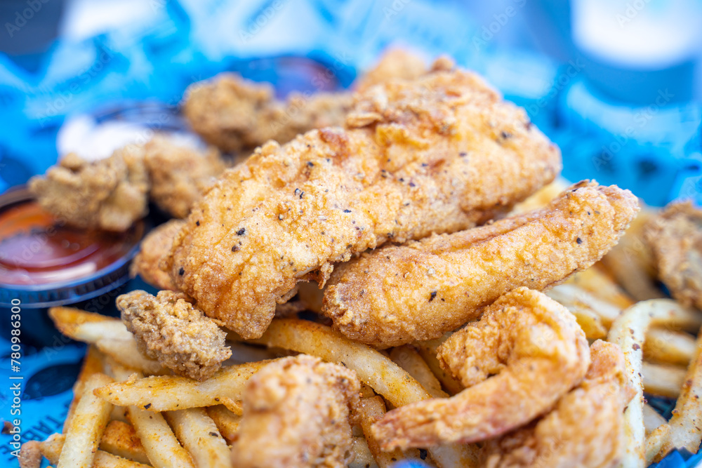 Fried seafood platter, a very common seafood meal for American to have during lunch or dinner. Fish, oyster, shrimps are dipped in dough and fried. Served with fried potatoes, ketchup, remoulade sauce Fried seafood platter, a very common seafood meal for American to have during lunch or dinner. Fish, oyster, shrimps are dipped in dough and fried. Served with fried potatoes, ketchup, remoulade sauce