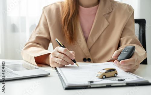 Car dealer businesswoman signing car insurance document or lease paper. Car loan and insurance concept