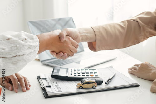 Businesswoman and brokers shake hands after completing negotiations to buy Car insurance and sign contracts. Car insurance concept