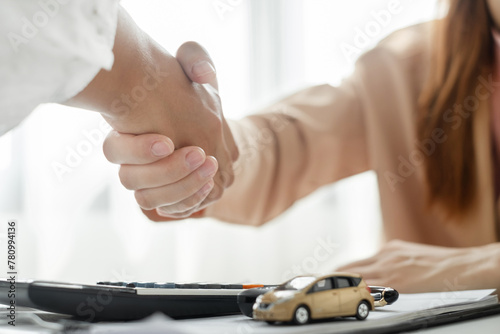 Businesswoman and brokers shake hands after completing negotiations to buy Car insurance and sign contracts. Car insurance concept