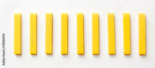 Array of cylindrical yellow cheese sticks placed neatly in a row, captured in a detailed close-up shot photo