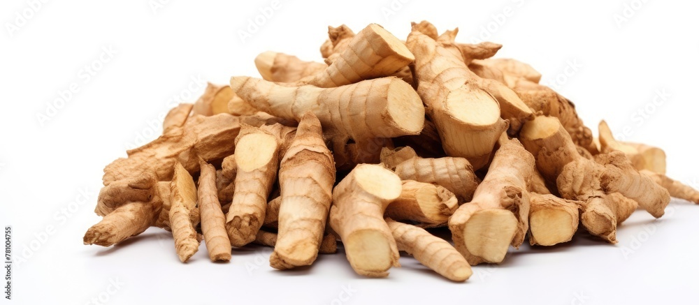 Fototapeta premium Pile of freshly cut ginger pieces arranged on a clean white background