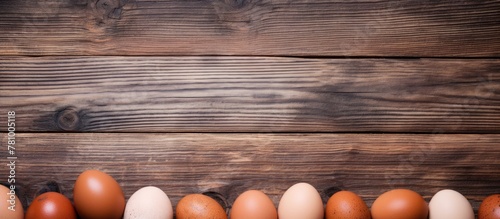 Arranged eggs in a neat row on top of a rustic wooden table or countertop