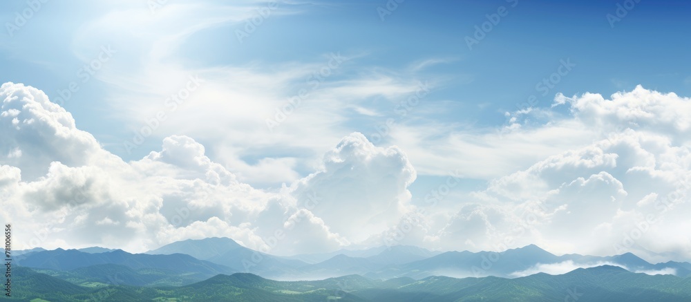 Landscape of mountains against cloudy sky with sun in background