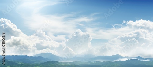 Landscape of mountains against cloudy sky with sun in background