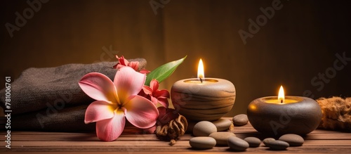Arrangement of candles, stones, and a flower set on a wooden table creating a serene and calming atmosphere