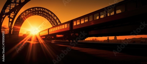 Train locomotive moving underneath a bridge during the sunset golden hour