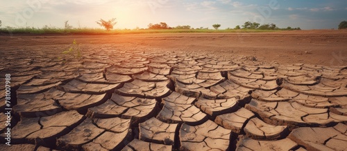 Cracked parched ground with glaring sun in the background, depicting intense heat and arid conditions
