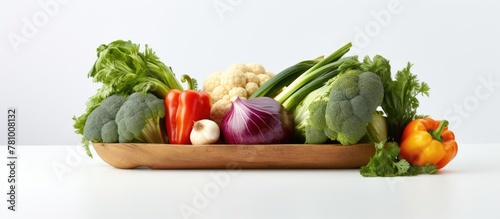 Bowl on table filled with various fresh vegetables like carrots and bell peppers