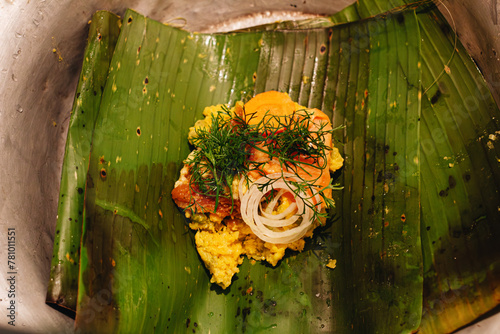 uncooked ingredients of a Colombian tamale on a banana leaf on a wooden table in the kitchen photo