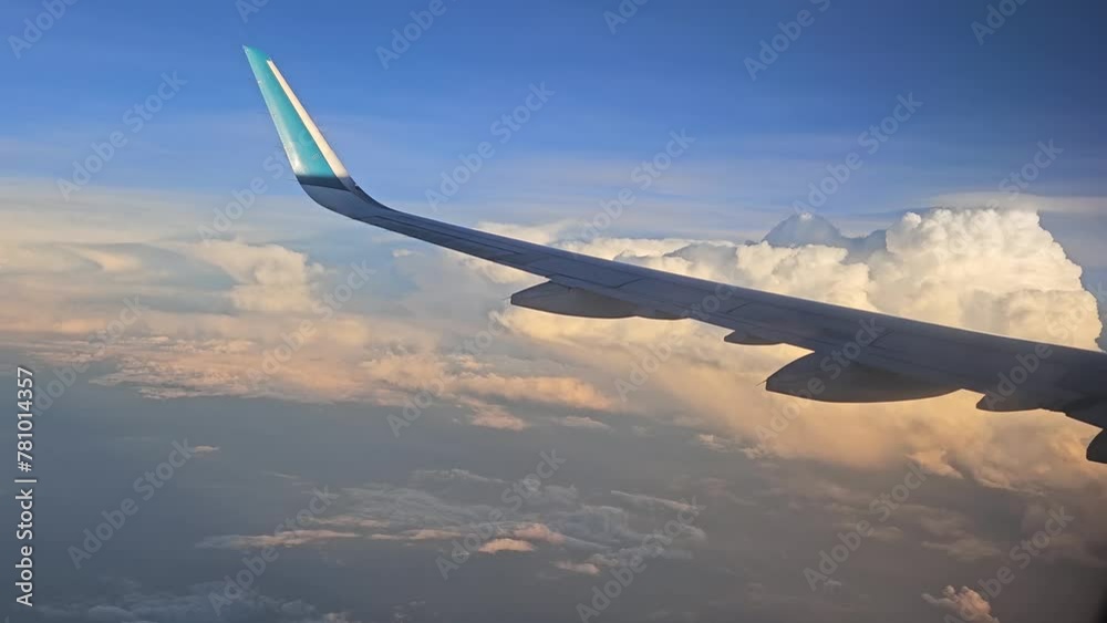  Flying above the blue sky clouds on sunset of airplane flight. View from the window of the airplane.