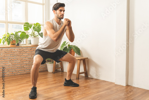 Handsome fitness caucasian young man, guy wearing sportswear training strength muscles workout, cardio exercise training in living room at home for healthy body strong athletic, fit active lifestyle