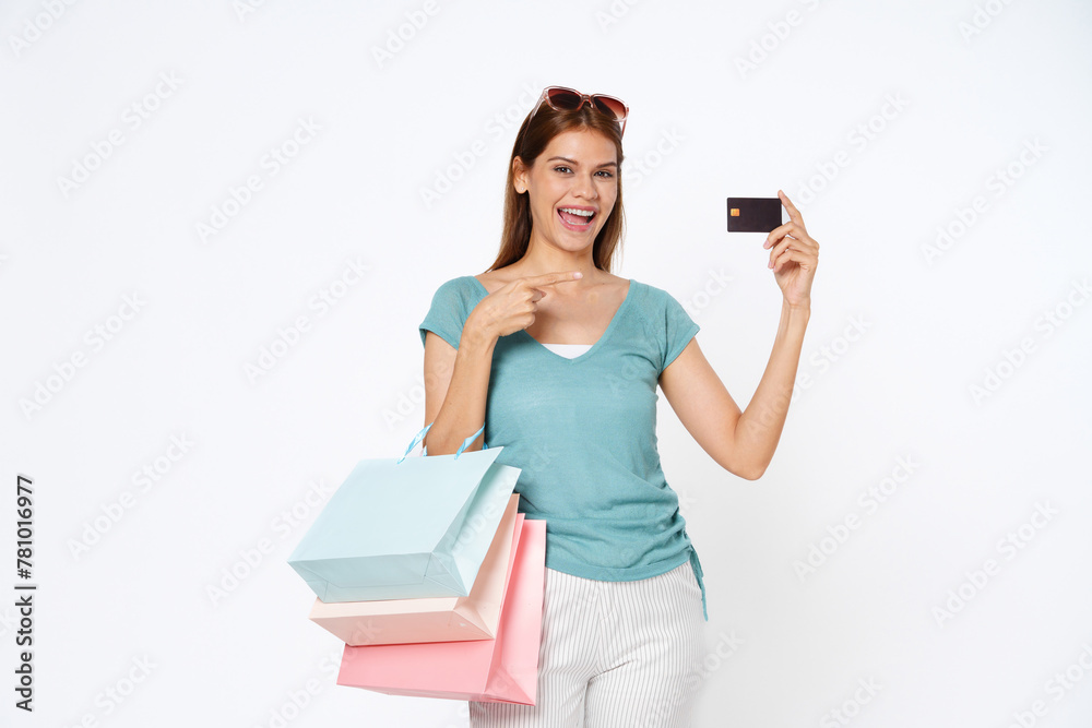 Happy young asian woman holding shopping bags and showing credit card isolated on white background. Happy young asian woman holding shopping bags and showing credit card isolated on white background.