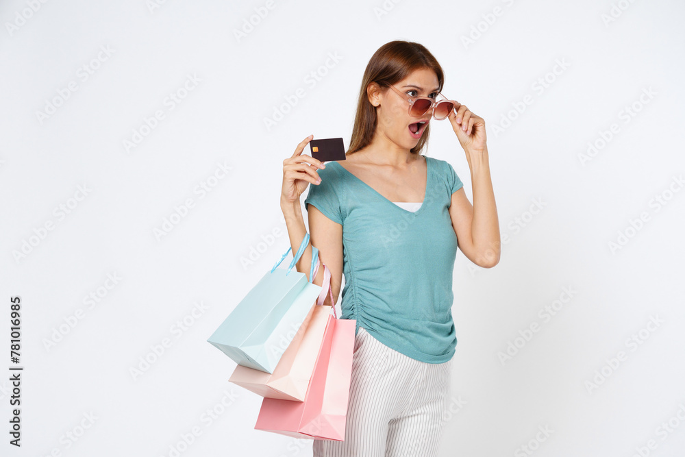 Excited young Asian woman holding credit card isolated and shopping bag on white background. Excited young Asian woman holding credit card isolated and shopping bag on white background.
