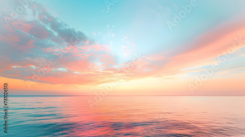 A beautiful sunset over the ocean with a few clouds in the sky. The sky is a mix of pink and blue colors photo