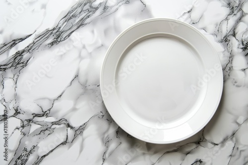 A white plate is placed on top of a marble counter, seen from an overhead side view photo
