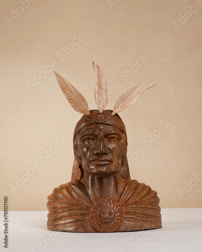Carved wood sculpture of the Inca hero Atahualpa on a brown background. Andean sculpture. Craft. Latin American culture.