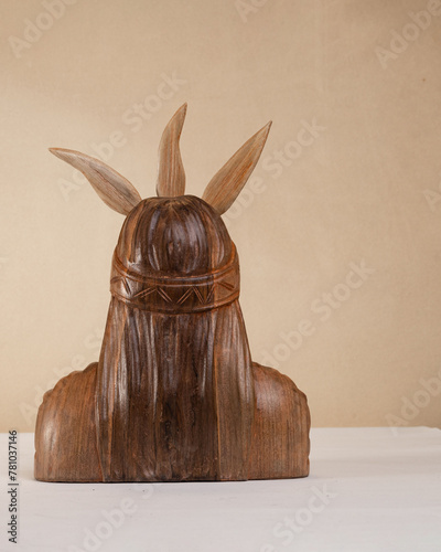 Carved wood sculpture of the Inca hero Atahualpa on a brown background. Andean sculpture. Craft. Latin American culture.