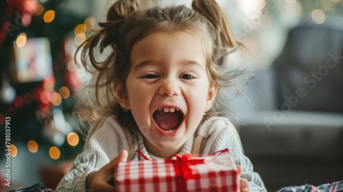 A child opening a gift with eager excitement and curiosity.  photo