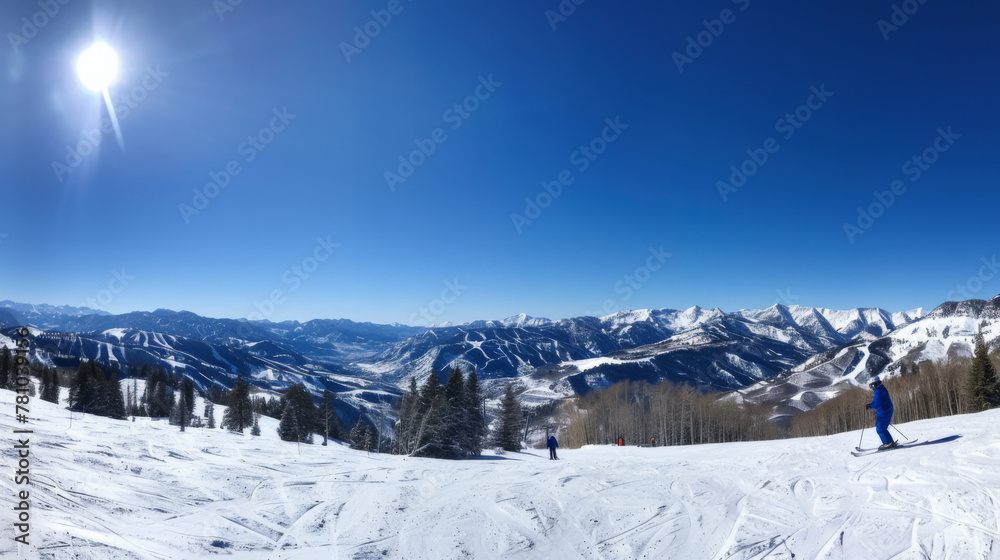 A ski slope with skiers on it and a clear blue sky