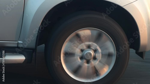 Rotating wheel of a car driving on the highway in the early evening
