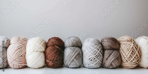 Assorted balls of yarn in earthy neutral colors neatly aligned. photo