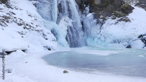 Helgufoss waterfall covered in ice. Early Spring. Iceland photo